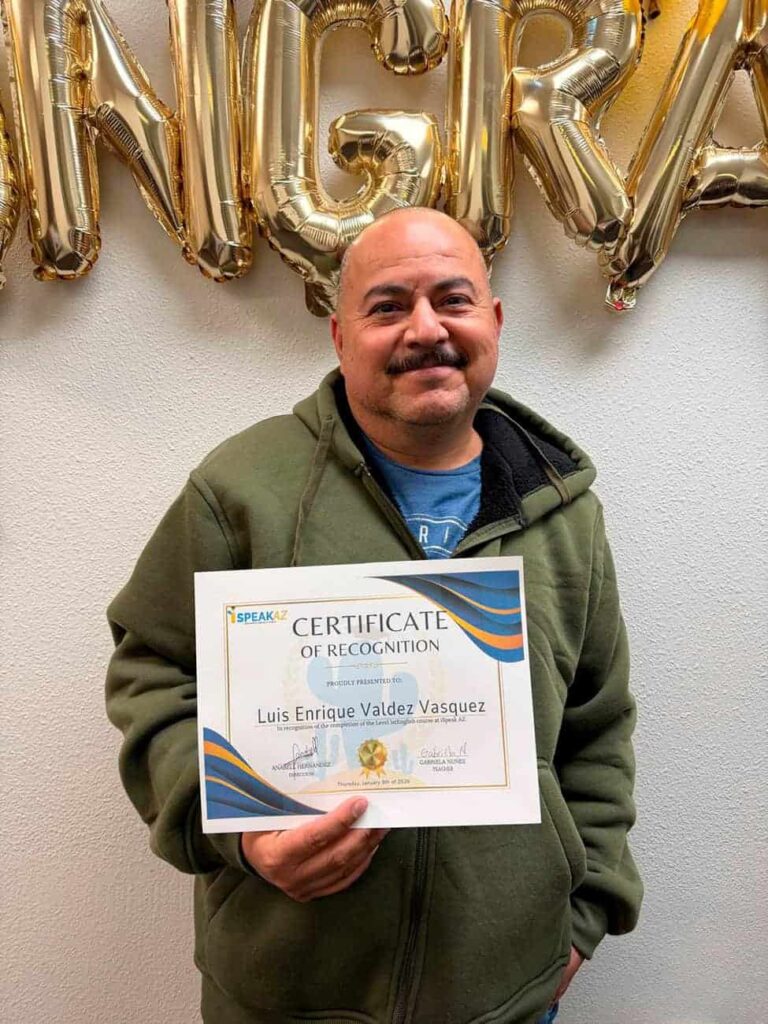 Alumno de iSpeakAZ Academy sosteniendo un certificado de reconocimiento tras completar su curso de inglés en Phoenix, Arizona.