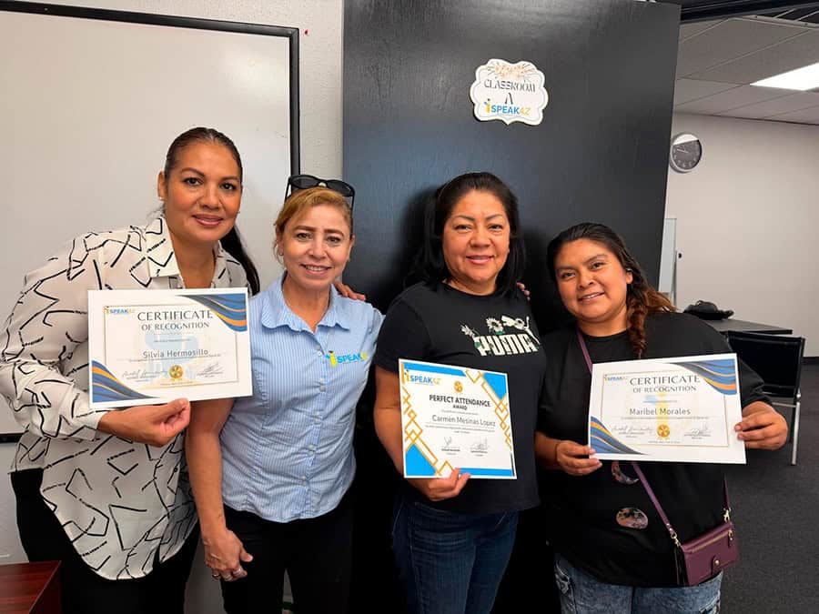 Grupo de estudiantes de iSpeakAZ Academy mostrando certificados de reconocimiento dentro de su escuela de inglés en Phoenix, Arizona.