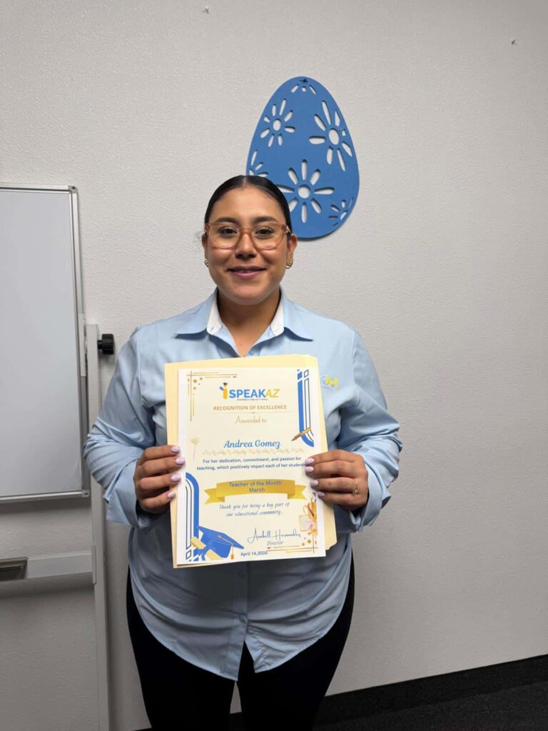 Profesora de iSpeakAZ Academy sosteniendo un certificado de reconocimiento dentro de la escuela de inglés en Phoenix, Arizona.