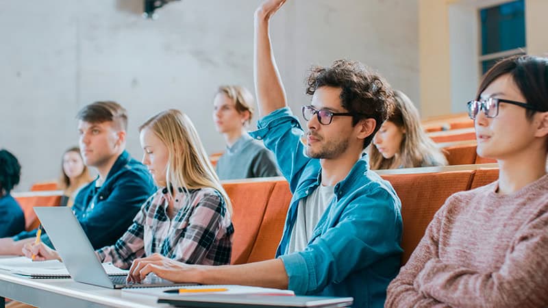 Fotografía de un salón de clases con estudiantes participando, útil para ilustrar clases de inglés para adultos en Phoenix.