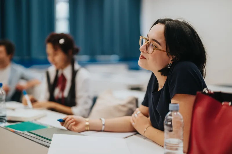 Estudiante joven con gafas prestando atencion en clase de ingles para adultos en arizona